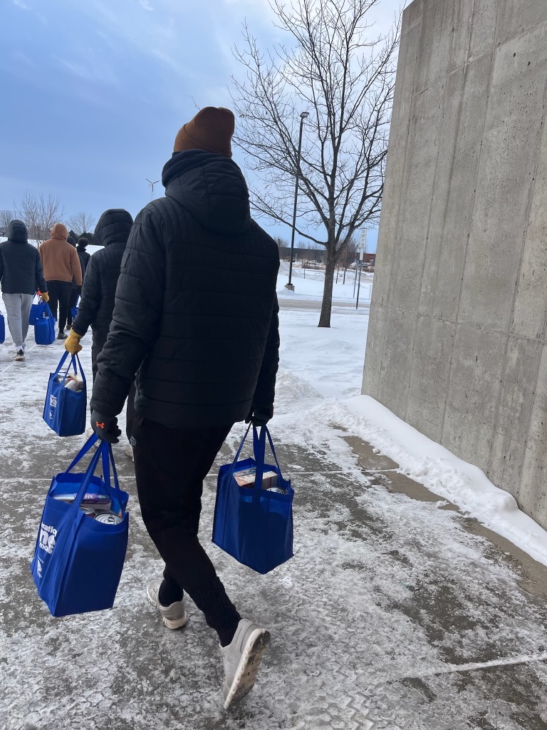 Volunteers carrying packed grocery bags for delivery